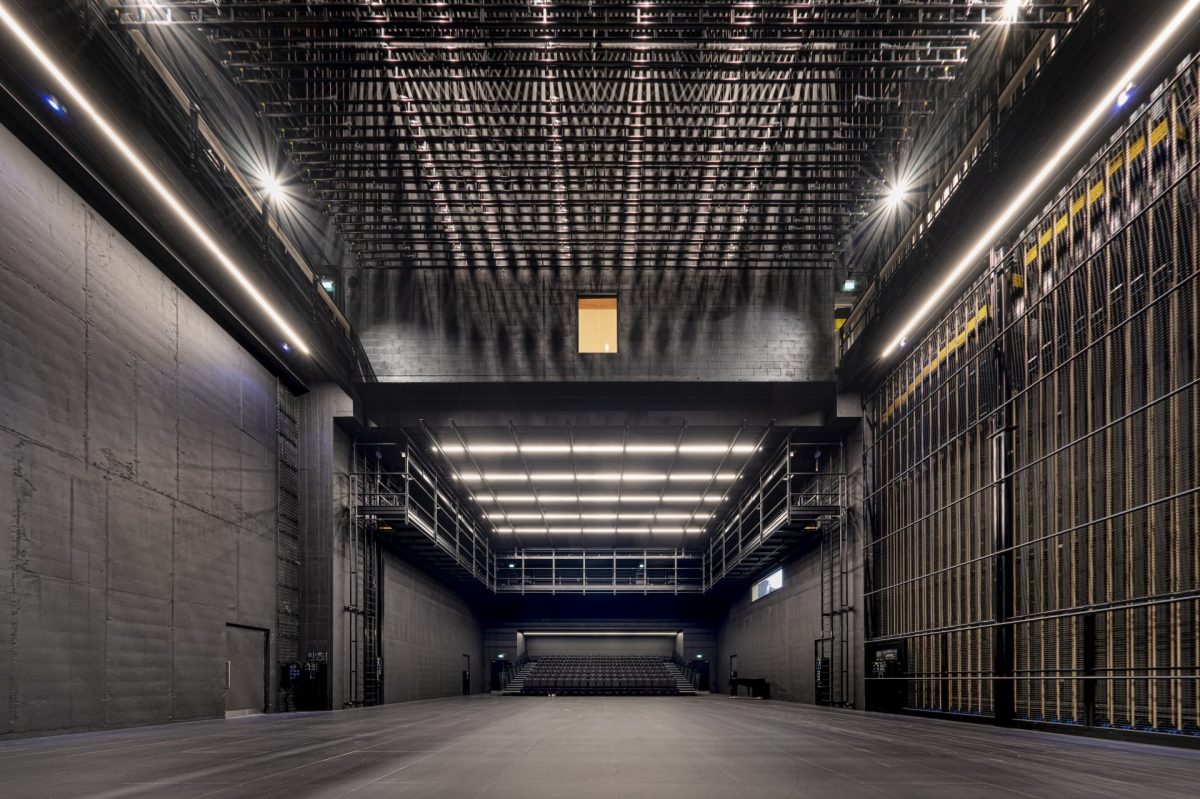 A production studio rental space, with black walls and seating at the back.